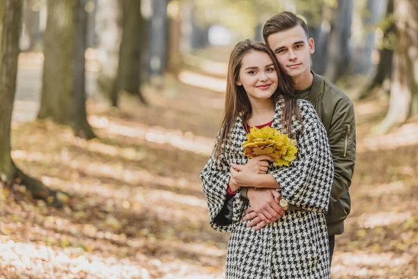 Ung familj som har kul bland gula träd och blad. — Stockfoto