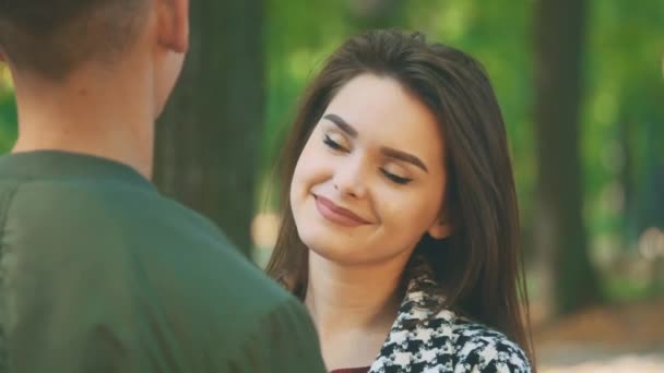 Adorable chica está hablando con su novio en el parque. Cambio sincero de emociones. De cerca. Copiar espacio. 4K . — Vídeos de Stock