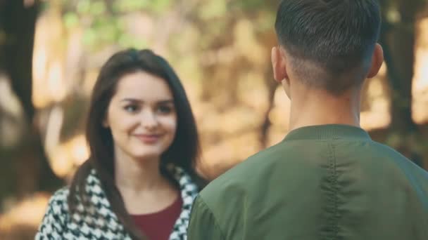 Adorable girl is coming closer and hugs her boyfriend in the park. Close up. Copy space. 4K. — Stock Video