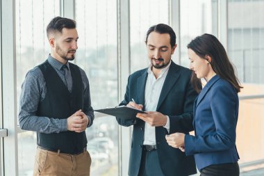 İki çalışanın portresi ve yeni bir proje imzalayan patronları..