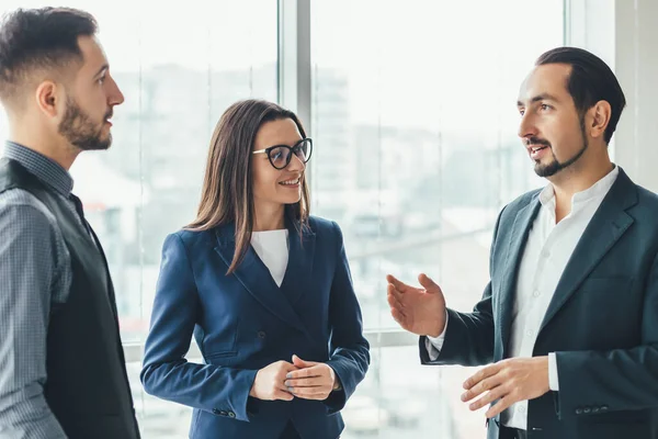 Equipo de trabajo alegre durante el descanso en la oficina, charlando animado . — Foto de Stock