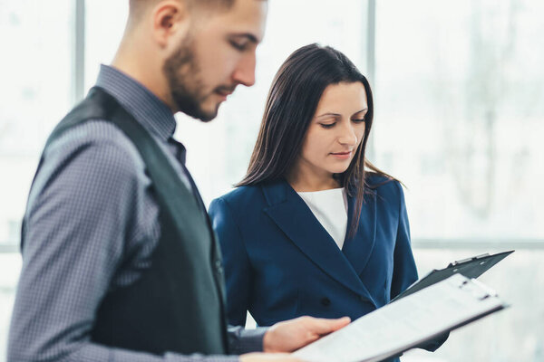 Вид двух сотрудников в костюмах, стоящих с бумагами, готовящихся к выступлению перед боссом, нервничающих
.