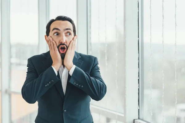 Hombre mirando sorprendido, con la boca abierta, sorprendido, manteniendo las manos en las mejillas, dándose cuenta de un nuevo pensamiento, idea o algunas noticias . —  Fotos de Stock