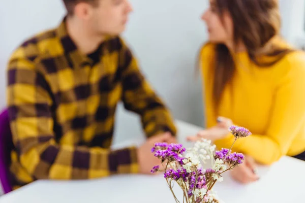 Обрізаний знімок романтичної пари з романтичною вечерею на спеціальній події. Фокус на фіолетових квітах на передньому плані . — стокове фото