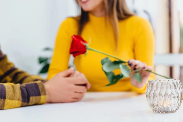 Coupé plan flou de jeune homme donne des fleurs à sa petite amie, lui tient la main et va certainement faire une proposition. — Photo