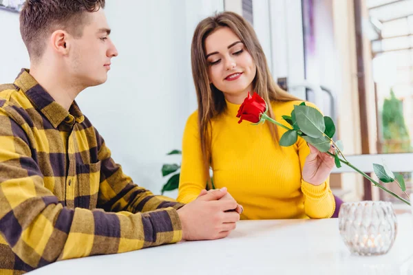 Concept d'appréciation. Belle femme souriante avec rose rouge à la main est vraiment reconnaissante à son homme bien-aimé pour un tel cadeau. — Photo