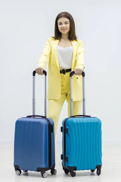 Reisende auf der Suche nach einem aufregenden Urlaubserlebnis, mit ihren Koffern vor weißem Hintergrund. — Stockfoto