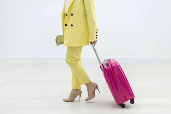 Colpo ritagliato di femmina che trasporta una valigia rosa e pssport su sfondo bianco con copyspace. — Foto Stock