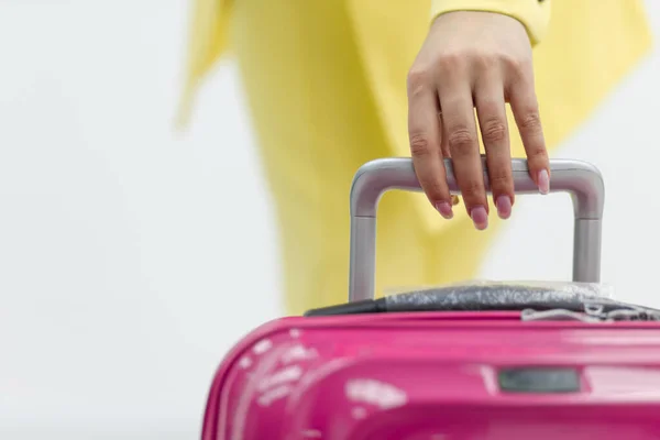Schnappschuss einer weiblichen Hand, die einen rosafarbenen Koffer über weißem Hintergrund mit Kopierraum trägt. — Stockfoto