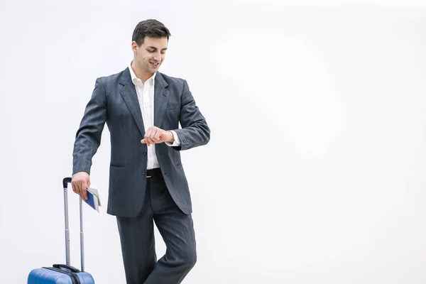 Drukke zakenman koffer op zoek naar zijn horloge op de luchthaven over witte achtergrond. — Stockfoto