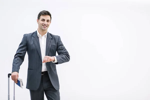 Busy businessman suitcase looking at his watch in the airport over white background. — Stock Photo, Image