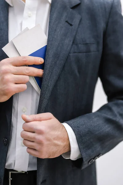 Cropped shot of businessman taking travel documents out of the inner pocket of his jacket. — Stock Photo, Image