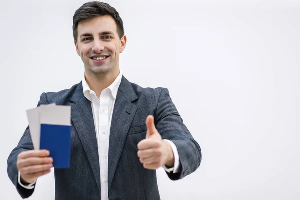 Close-up van de man met de tickets voor het vliegtuig en het paspoort klaar om te reizen, geïsoleerd op witte achtergrond. — Stockfoto