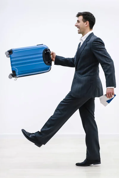 Man in formele kleding en met een blauwe koffer haast, rent. Geïsoleerd op witte achtergrond. — Stockfoto