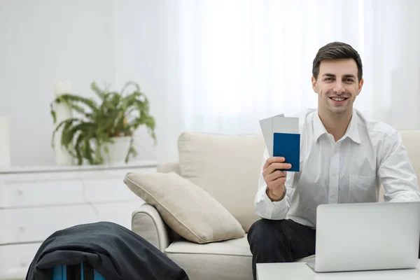Young man using laptop to book airplane tickets or do online check-in at home. — Stock Photo, Image