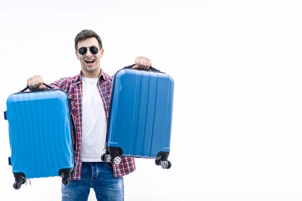 Фото счастливого молодого человека, готового к путешествию с чемоданом, упакованным на белом фоне . — стоковое фото