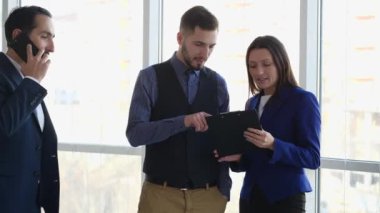 İş adamları arka plandaki bulanık ışık sorununu tartışıyorlar. Telefondaki adam ön cephede. Evet, tebrikler. Yumruklar yukarı. Uzayı kopyala Kapatın. 4K.