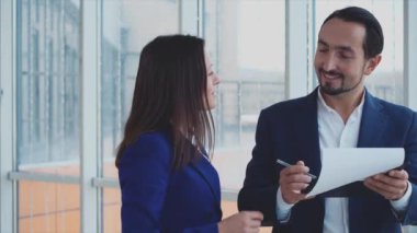 Erkek ve kadın iş adamları sorunları tartışıyor. Başarılı bir takım. Uzayı kopyala Patron belgeleri imzalıyor. Bulanık beyaz arka plan. Kapatın. 4K.