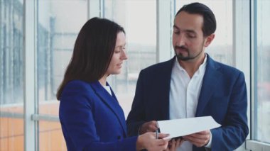 Erkek ve kadın iş adamları sorunları tartışıyor. Başarılı bir takım. Uzayı kopyala Patron belgeleri imzalıyor. Bulanık beyaz arka plan. Kapatın. 4K.