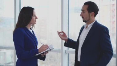 Kapatın. İşçiler sorunları tartışıyor. Uzayı kopyala Kadın önemli bilgiler yazıyor. Başarılı bir anlaşma. Arka plan bulanık. 4K.