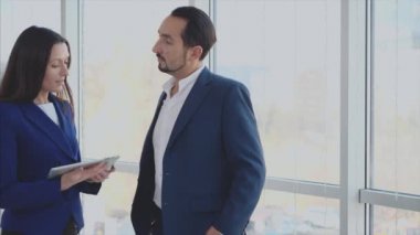 Kapatın. İşçiler sorunları tartışıyor. Uzayı kopyala Kadın önemli bir bilgi vermiyor. Başarılı bir anlaşma. Arka plan bulanık. 4K.