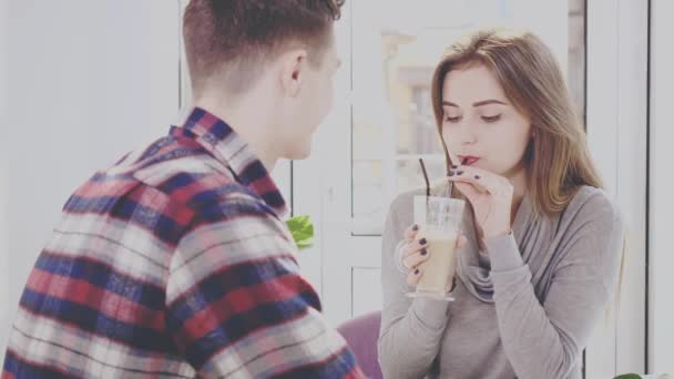 Um homem amoroso com uma modesta rapariga está a falar num café no sótão. Encontro romântico num café. Acção. Animação. 4K . — Vídeo de Stock