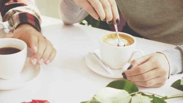 若者のカップルがカフェにいます。男と女はカプチーノを飲みに行った。閉めろ。コピースペース。行動だ。アニメーション。4K. — ストック動画