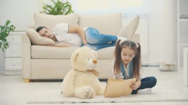 4K yavaş çekim videosunda babasıyla kitap okuyan sevimli küçük bir kız..