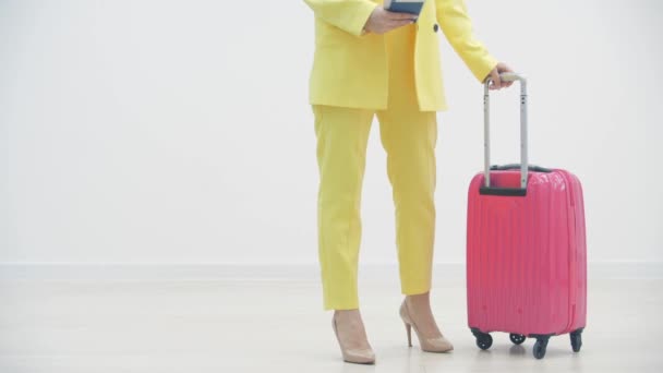 Vídeo em câmera lenta cortada de mulher carregando uma mala e passaporte sobre fundo branco com copyspace . — Vídeo de Stock