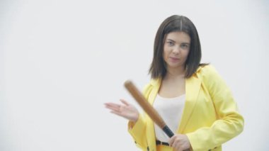 Beyzbol sopasıyla beyaz arka planda kameraya bakan kötü kız..