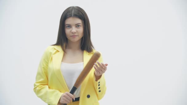 Böses Mädchen mit Baseballschläger blickt vor weißem Hintergrund in die Kamera. — Stockvideo