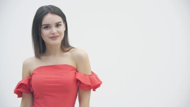遅いです動きの若いです壮大な女性porningでトレンディーな赤いドレス上の白い背景. — ストック動画