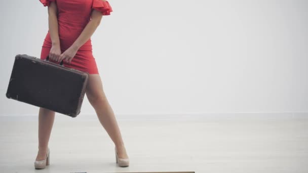 Vídeo en cámara lenta recortado de mujer en vestido rojo sosteniendo un maletín de cuero esperando en línea aislada sobre fondo blanco . — Vídeos de Stock