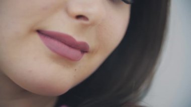 Pembe lale kokan, kameraya hafifçe gülümseyen, barışçıl görünen genç bir kadının yavaş çekim videosu..