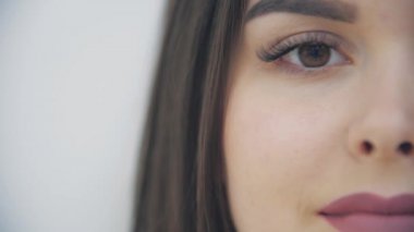 Çekici görünüşlü, güzel gülüşlü, beyaz arka planda harika bir kadının yarım yamalak videosu..