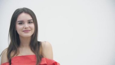 İşaret gibi görünen, göz kırpan ve gülümseyen güzel bir kızın 4K videosunu kapat..