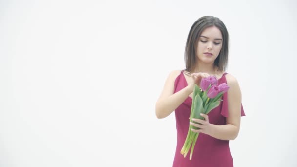 Movimento lento da jovem mulher bonita segurando um buquê de primavera e apreciando o cheiro de flores frescas . — Vídeo de Stock