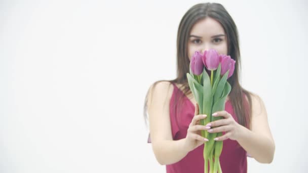 Lento movimiento de la joven hermosa mujer sosteniendo un ramo de primavera y disfrutando del aroma de flores frescas . — Vídeos de Stock