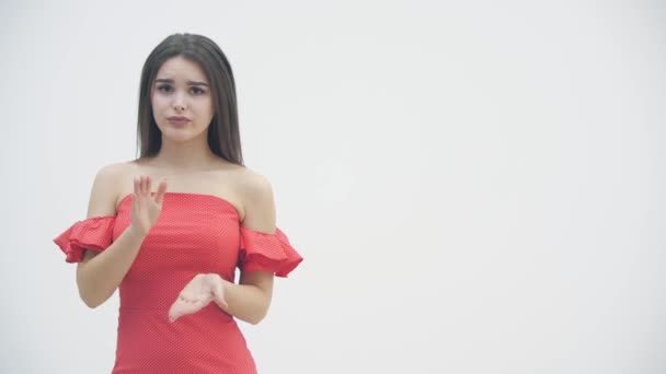 4k-Video einer jungen brünetten Frau, die wegen schlechter Nachrichten die Stirn runzelt, während sie über weißem Hintergrund steht. — Stockvideo