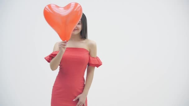 4k video van vrolijke dame rommelen rond verbergen achter een hartballon en het maken van domme gezichten. — Stockvideo