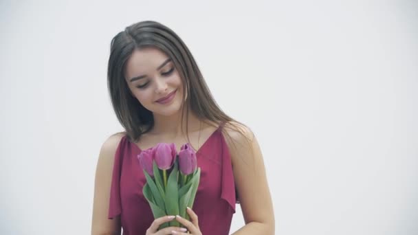 Feliz Día de la Mujer. 4k video de mujer emocionada se para con un montón de tulipanes con motivo de las vacaciones femeninas de primavera . — Vídeos de Stock