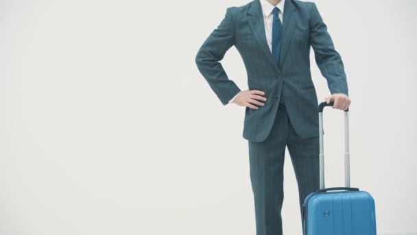 Zeitlupe eines jungen, gut aussehenden Geschäftsmannes im Anzug, kommt mit einem Koffer, am Bahnhof, am Flughafen. — Stockvideo