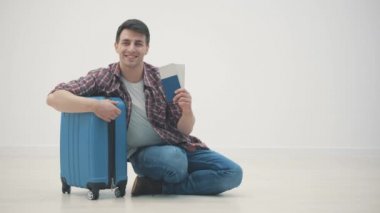 Havaalanı terminalinde bagajlarıyla bekleyen yorgun turistin yavaş çekim videosu..