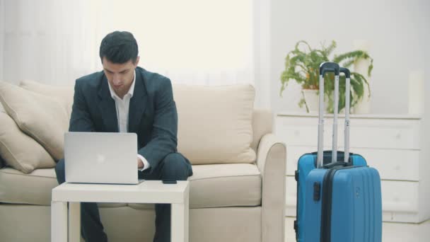 Lentitud de hombre joven que utiliza el ordenador portátil para reservar billetes de avión o hacer el check-in en línea en casa . — Vídeo de stock