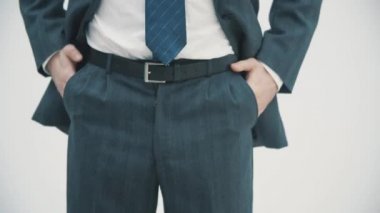 Koyu takım elbiseli ve mavi kravatlı işadamının beyaz arka plan üzerine ellerini koyduğu görüntüler..