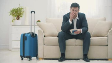 Kafkasyalı iş gezgini, uzun bir yolculuktan sonra otel yatağına yorgun bir şekilde tırmanıyor..