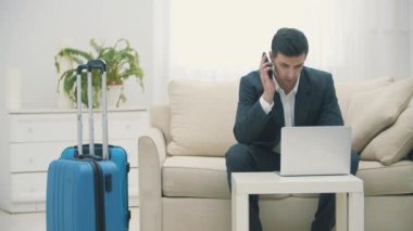 Genç bir adamın uçak bileti almak için dizüstü bilgisayar kullanmasını ya da evde online giriş yapmasını gösteren bir video..