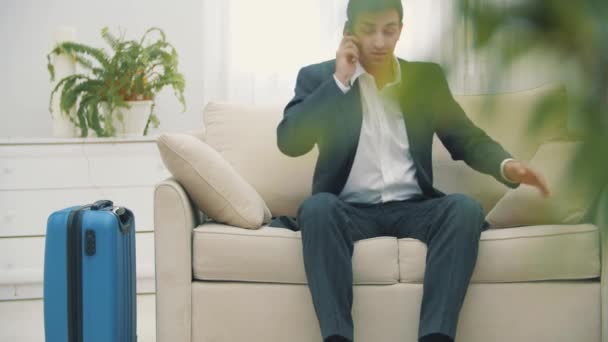 Vidéo 4k d'un beau jeune homme parlant au téléphone à l'hôtel pendant son voyage d'affaires. — Video