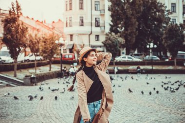 Hasır şapkalı genç bir kadın, yolculuğunun tadını çıkarıyor, sokakta uyanıyor ve meydanda....