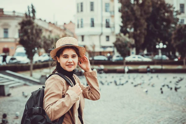 Gadis berambut cokelat lucu dengan topi lucu dalam perjalanan ke universitas pada hari pertamanya di luar negeri. — Stok Foto
